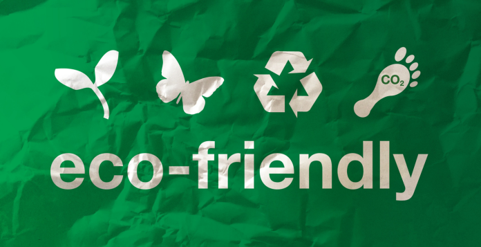 green flag with a white leaf, butterfly symbol of recycle and footprint with Co2 written in