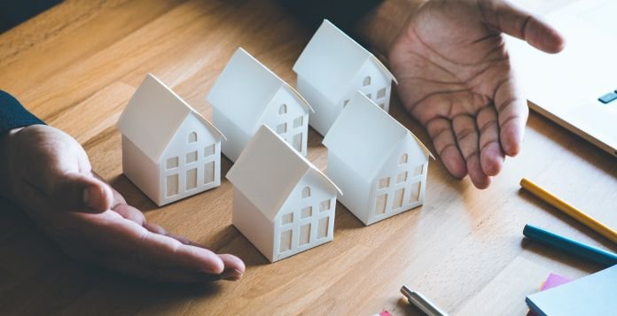 man presenting 5 homes on a table